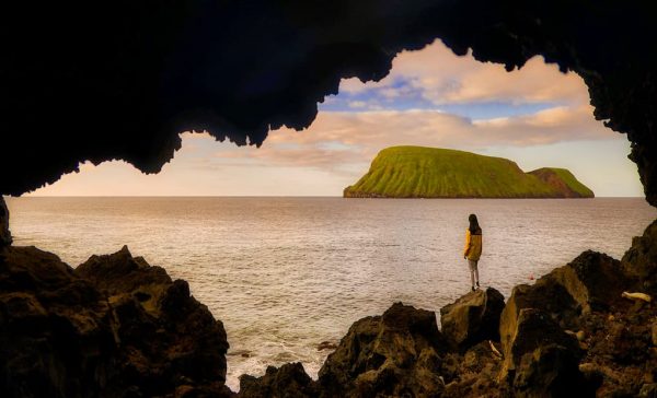 rapariga a olhar para o mar atraves de uma gruta - Ilha terceira