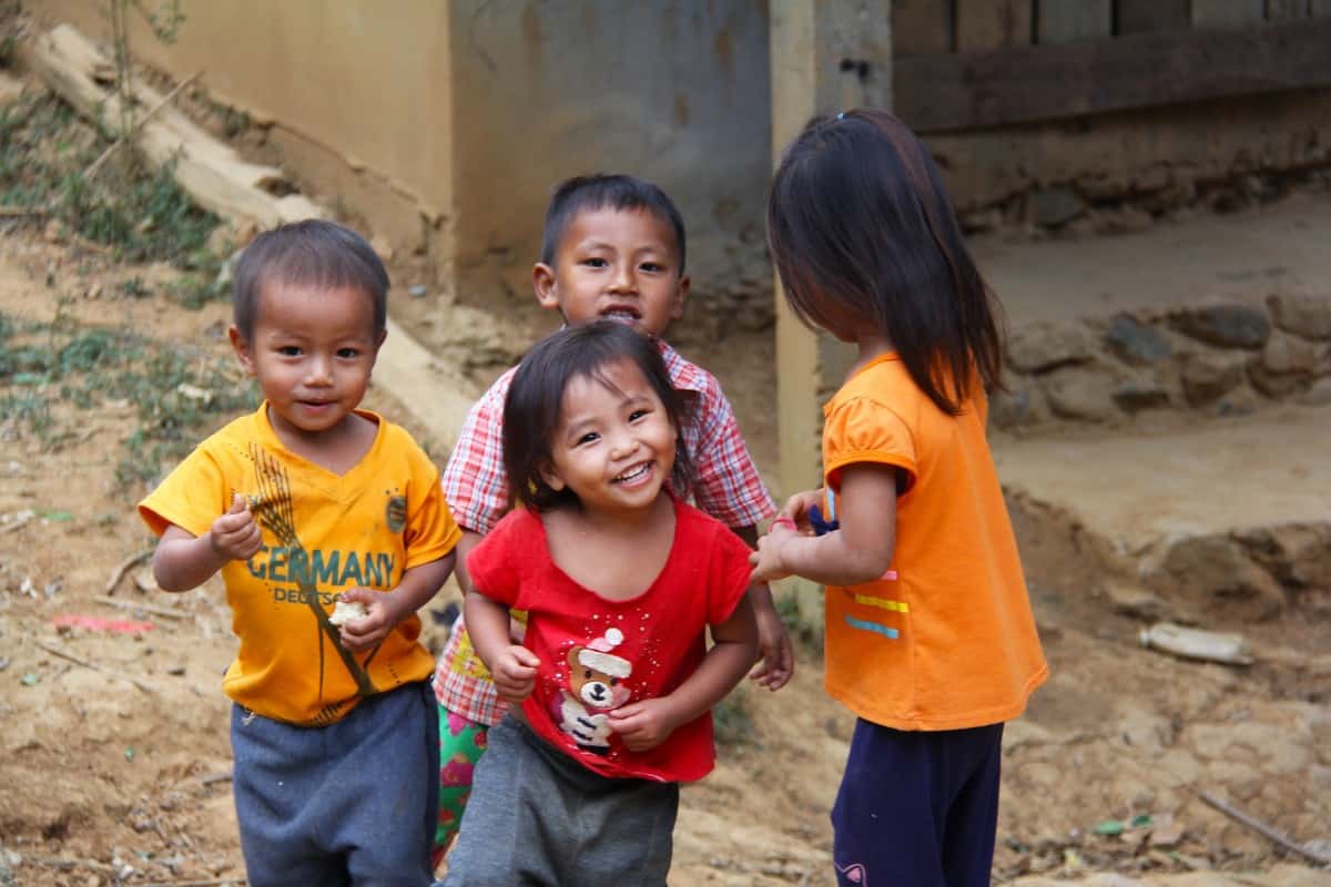 grupo de crianças sorri para a camara - viajar durante a pandemia