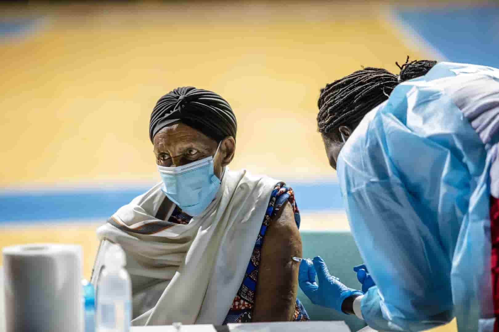 Senhora recebe vacina - viajar durante a pandemia