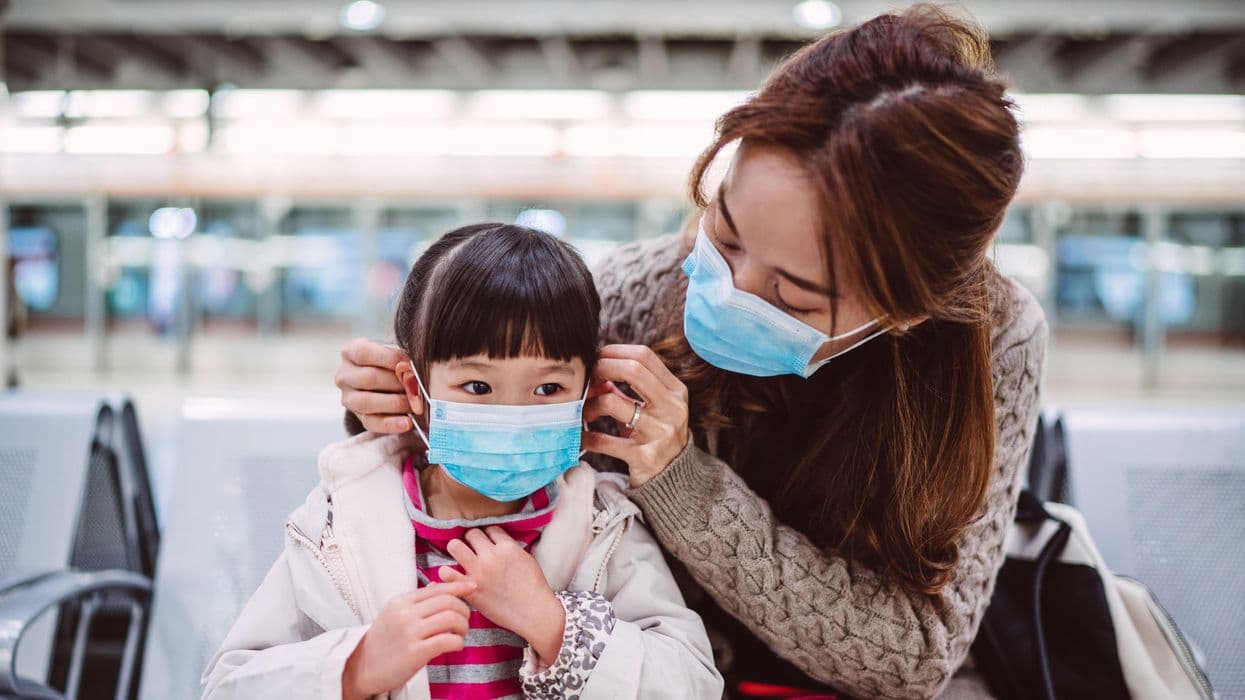 mãe e filha com mascara no aeroporto